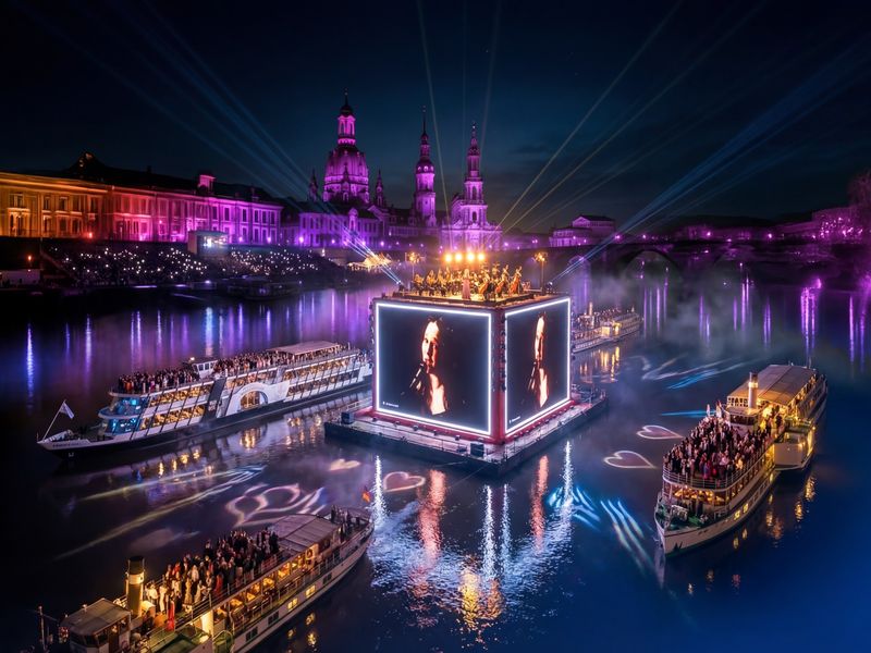 Blick auf die beleuchteten Dampfschiffe, LED-Kubus auf dem Wasser und Dresdner Altstadt bei Nacht